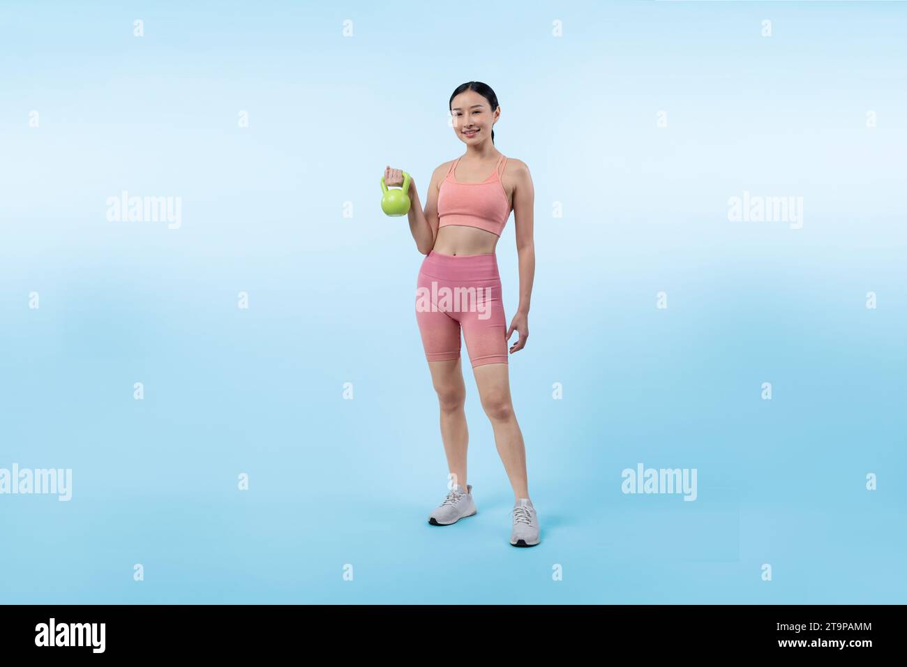 Vigorous energetic woman doing kettlebell weight lifting exercise on