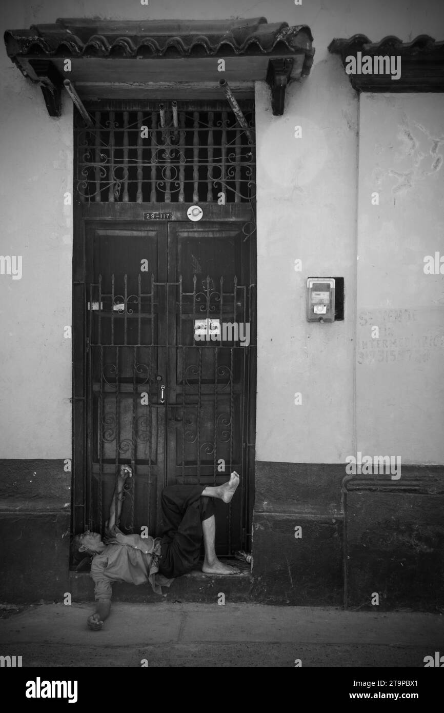 An intoxicated poor man lies unattended in the streets of Cartagena, Colombia Stock Photo