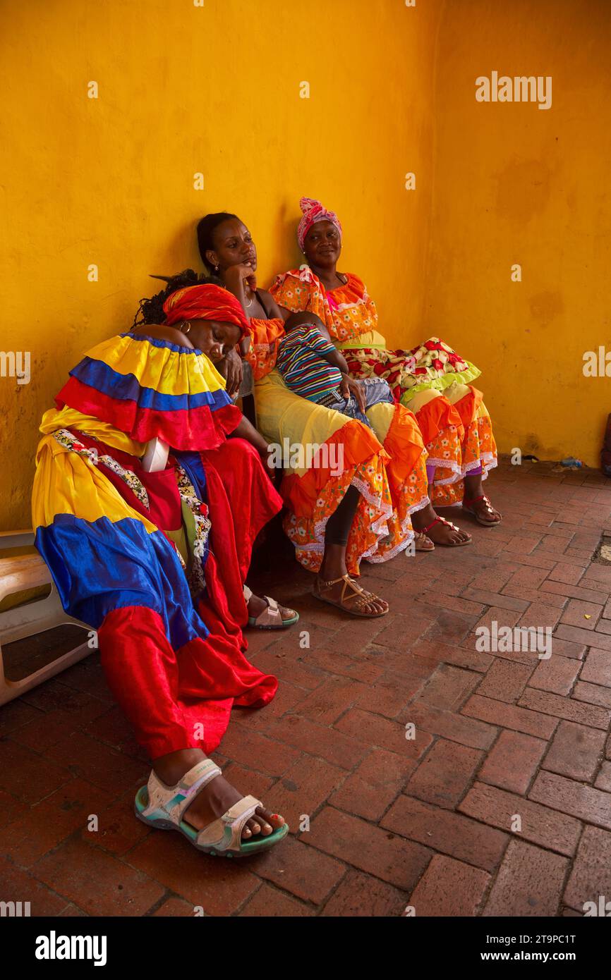 Three Palenqueras fall exhausted after a day selling fruit in the streets of Cartagena, Colombia Stock Photo