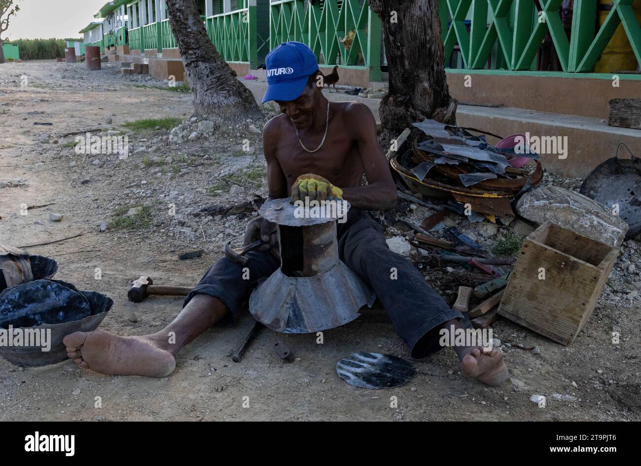 A sugar cane worker builds a makeshift stove out of reused sheets of metal in a Central Romana batey, or community, in El Seibo, Dominican Republic on Nov. 21, 2023. Bateyes are home to sugar cane workers and their families. Most residents of these communities are either undocumented Haitian immigrants or denationalized Dominicans of Haitian descent. The United States blocked the Central Romana Corporation, Ltd. from importing sugar into the country on Nov. 23, 2022 after allegations of forced labor were levied against the company. (Photo by Carlos Berríos Polanco/Sipa USA) Stock Photo