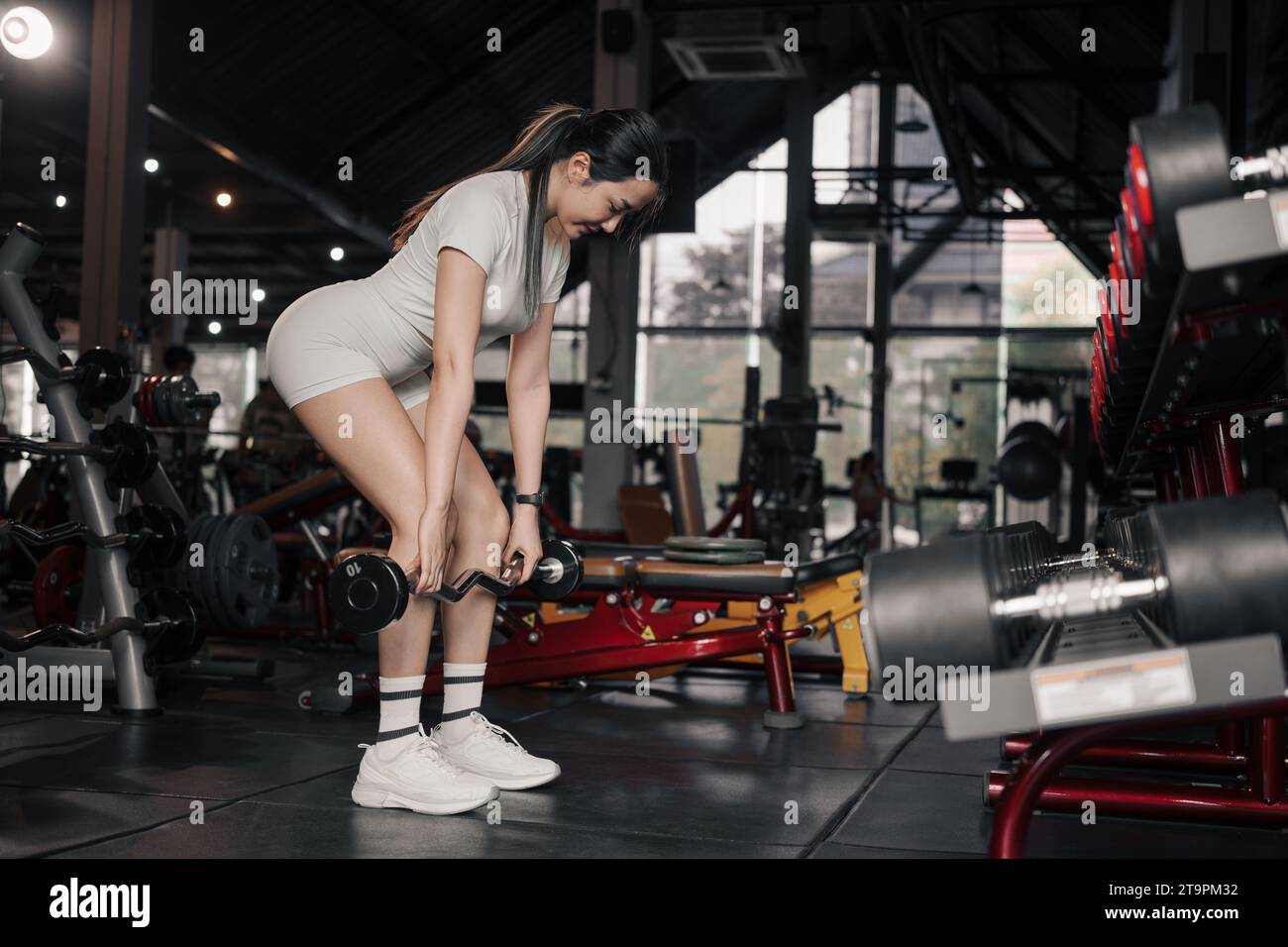 Young Asian woman lifting weights in the gym. Stock Photo