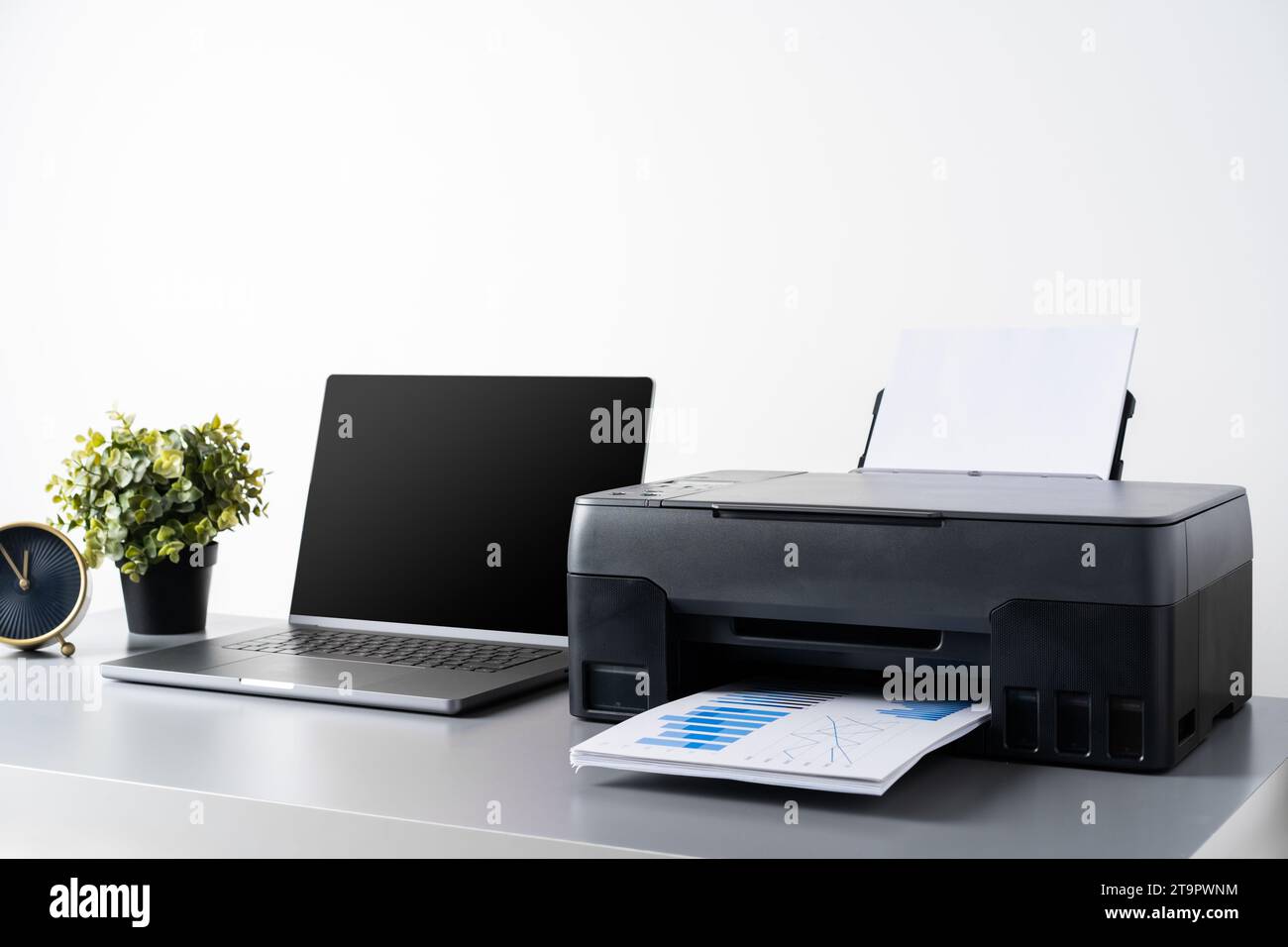 Printer and laptop on grey table in office Stock Photo