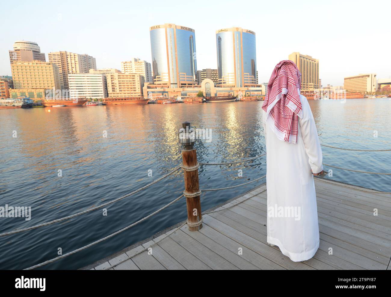 A Saudi man enjoying the views of the Dubai Creek and Deira in Dubai, United Arab Emirates. Stock Photo
