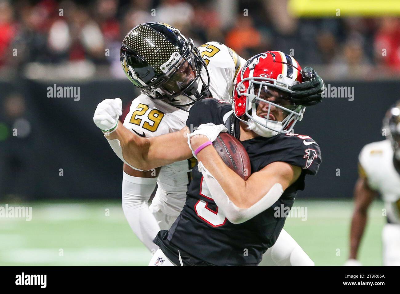 Atlanta, Georgia, USA. 26th Nov, 2023. Atlanta Falcons wide receiver Drake London (5) runs with the ball as New Orleans Saints cornerback Paulson Adebo (29) hangs on to the face mask during the game at Mercedes-Benz Stadium. (Credit Image: © Debby Wong/ZUMA Press Wire) EDITORIAL USAGE ONLY! Not for Commercial USAGE! Credit: ZUMA Press, Inc./Alamy Live News Stock Photo