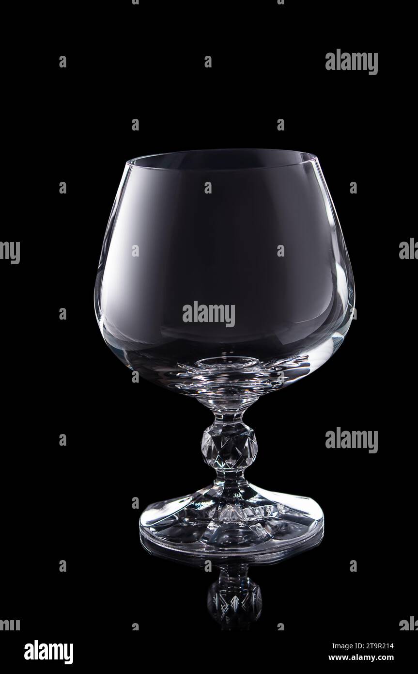 empty brendy glass isolated on black background Stock Photo