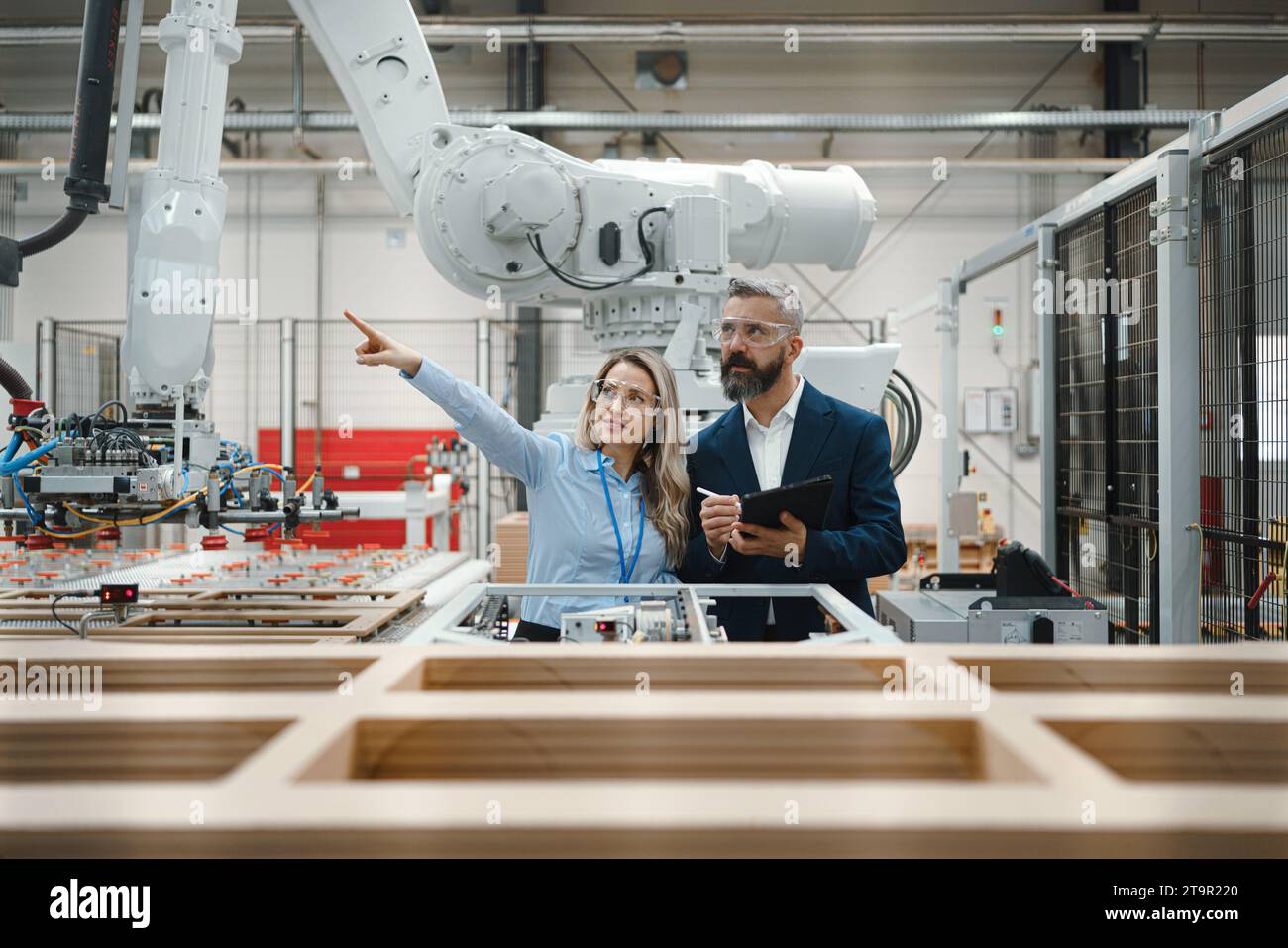 Female engineer and male project manager standing in modern industrial