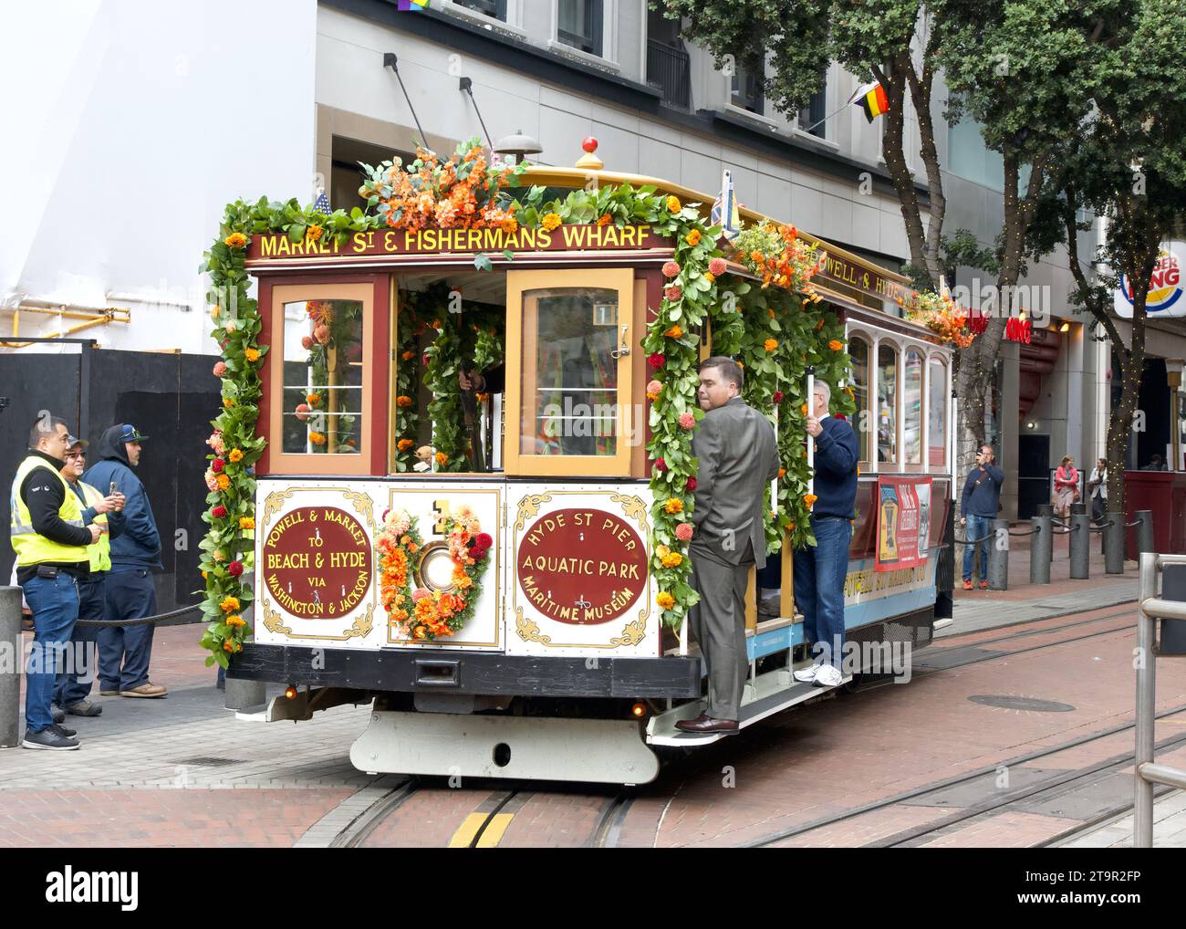 San Francisco, CA - Aug 2, 2023: Participants dressed in 1800 era fashions at the 150th celebration of the First Cable Car Ride, trolly 1 enters Powel Stock Photo