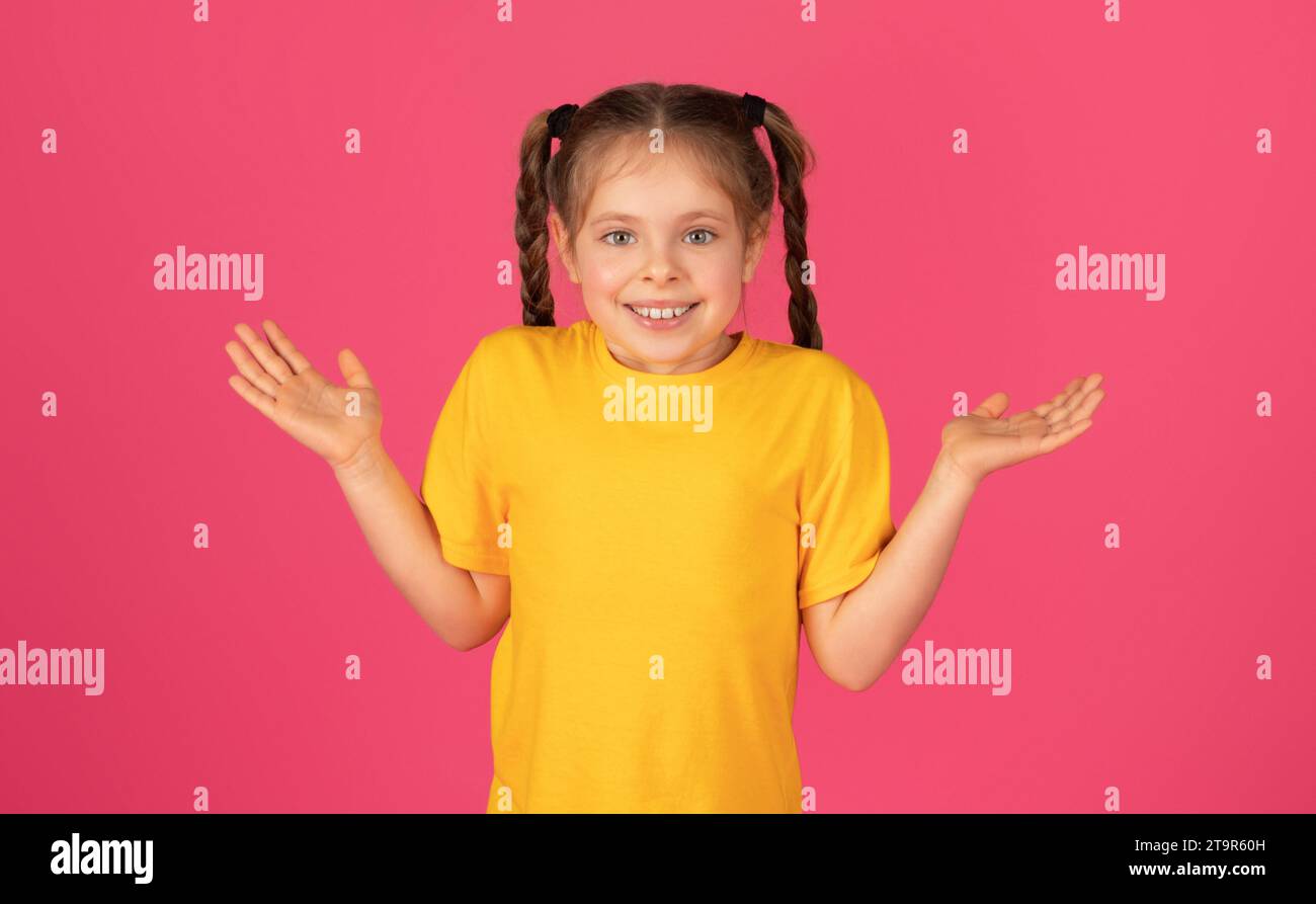 Cheerful preteen girl with pigtails shrugging her shoulders in playful