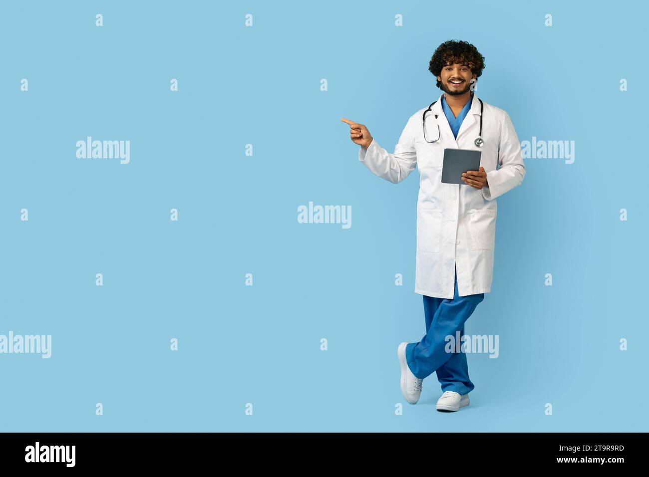 Smiling Confident Indian Doctor Using Digital Tablet Stock Photo