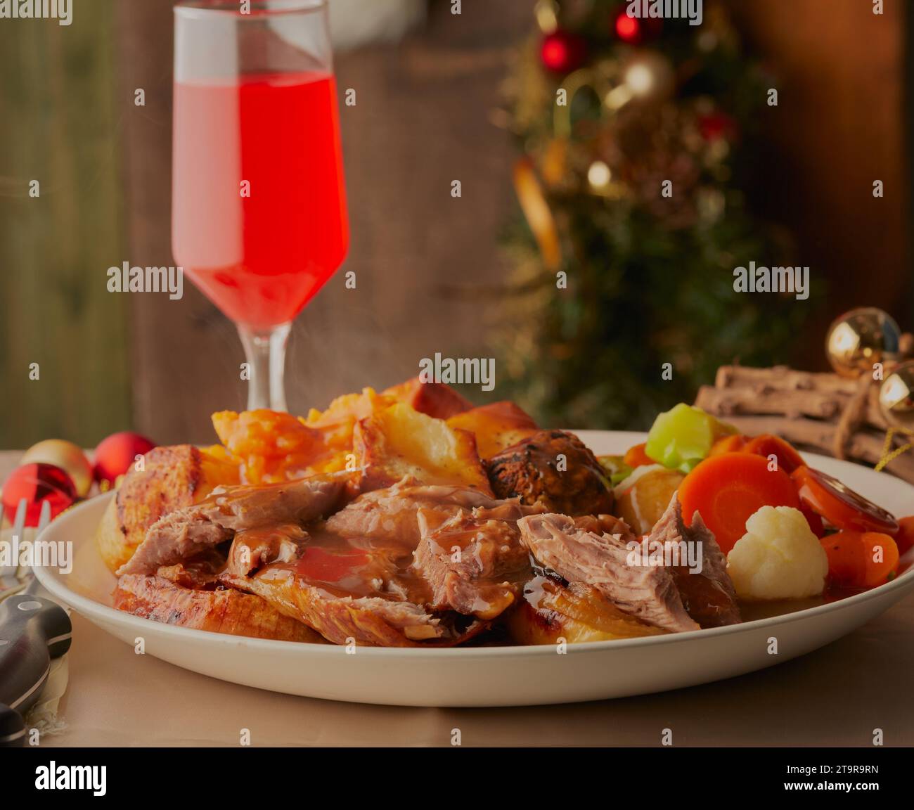 Christmas turkey dinner with decorations and a glass of red wine. Stock Photo