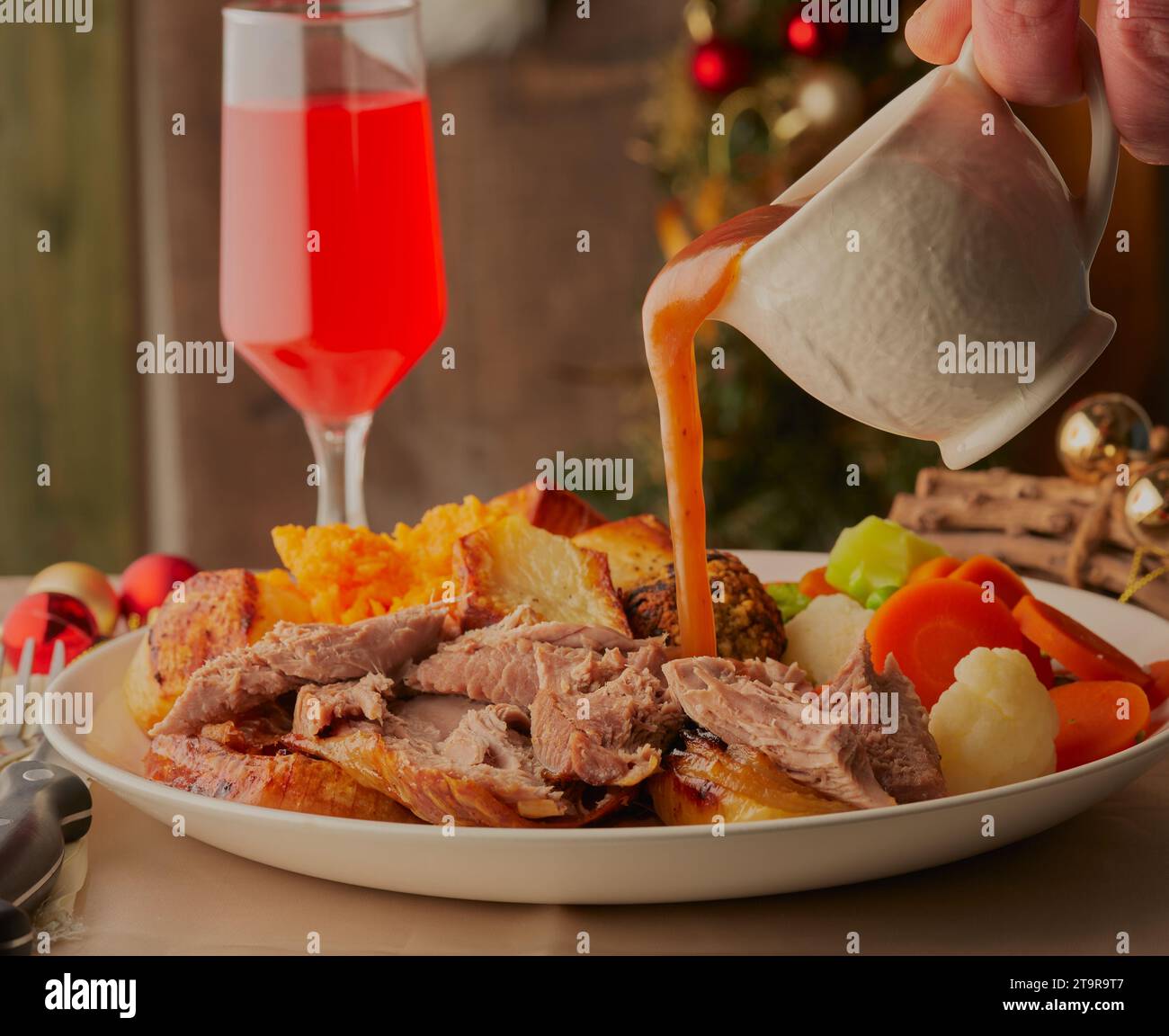 Christmas turkey dinner with gravy being poured over it. Stock Photo