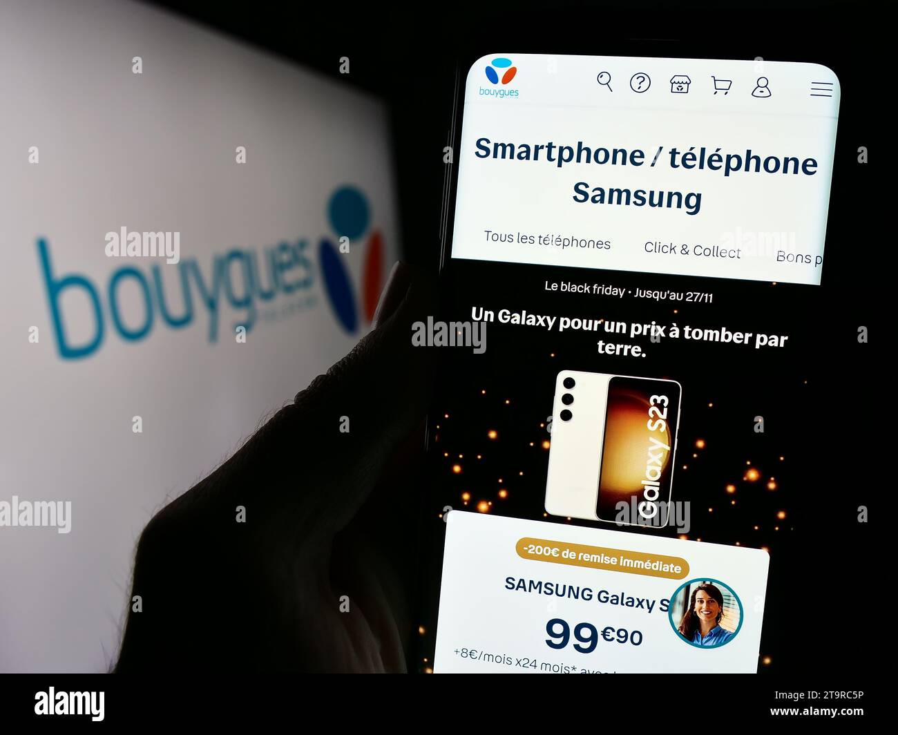 Person holding cellphone with webpage of French telecommunications company Bouygues Telecom S.A. with logo. Focus on center of phone display. Stock Photo
