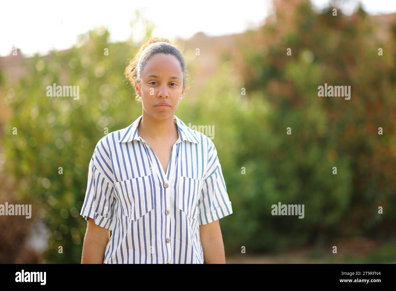 Serious black woman looking at you in a park Stock Photo