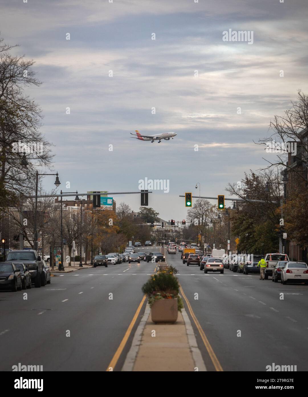 An Iberia Airlines A330 flying over a busy street prior to landing in Boston after a flight from Spain. Stock Photo