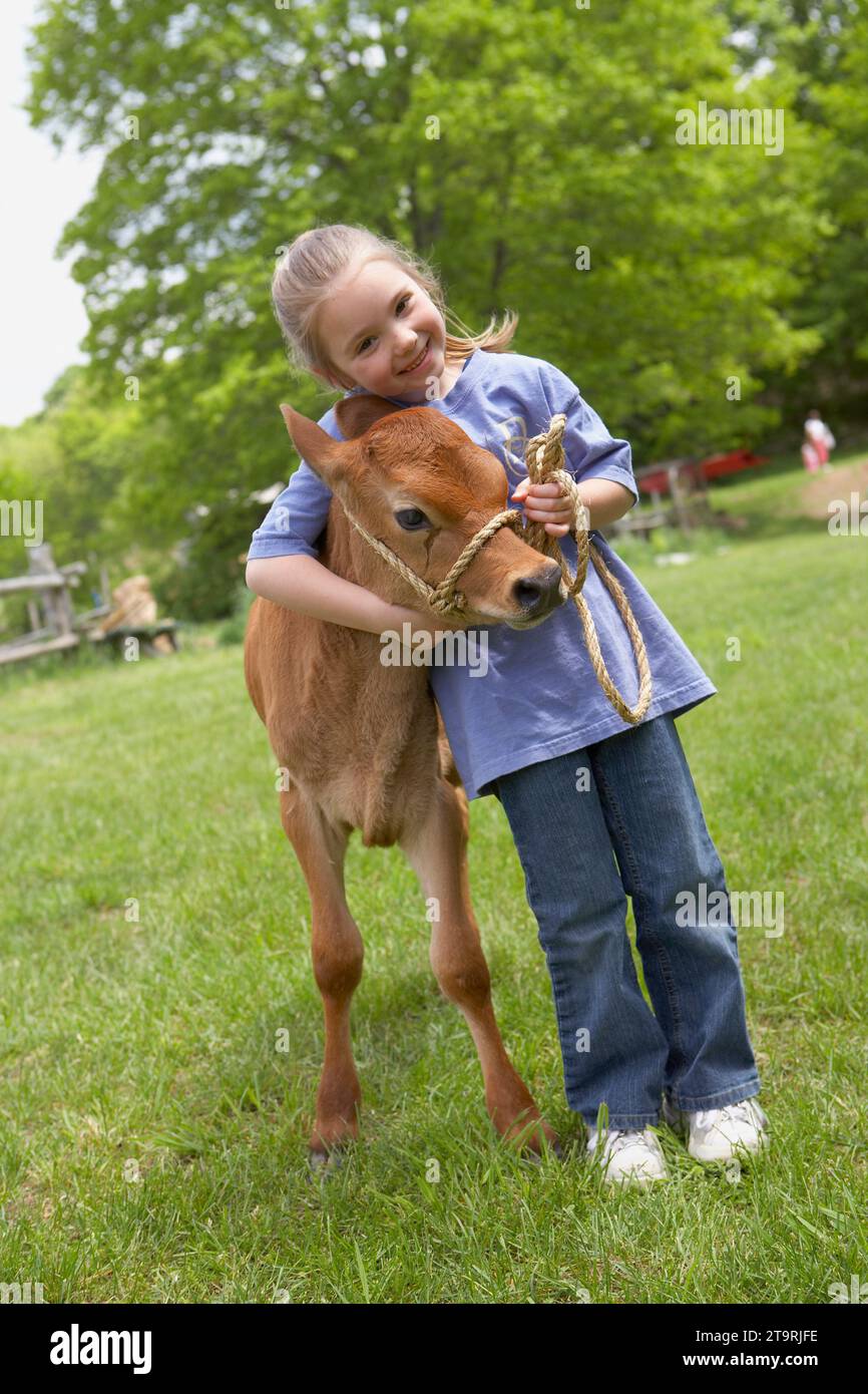 A little girl hugging a baby cow at a farm in Madison, CT. Stock Photo