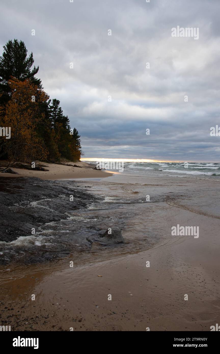 Chilly autumn sunset over the beach with incoming waves Stock Photo
