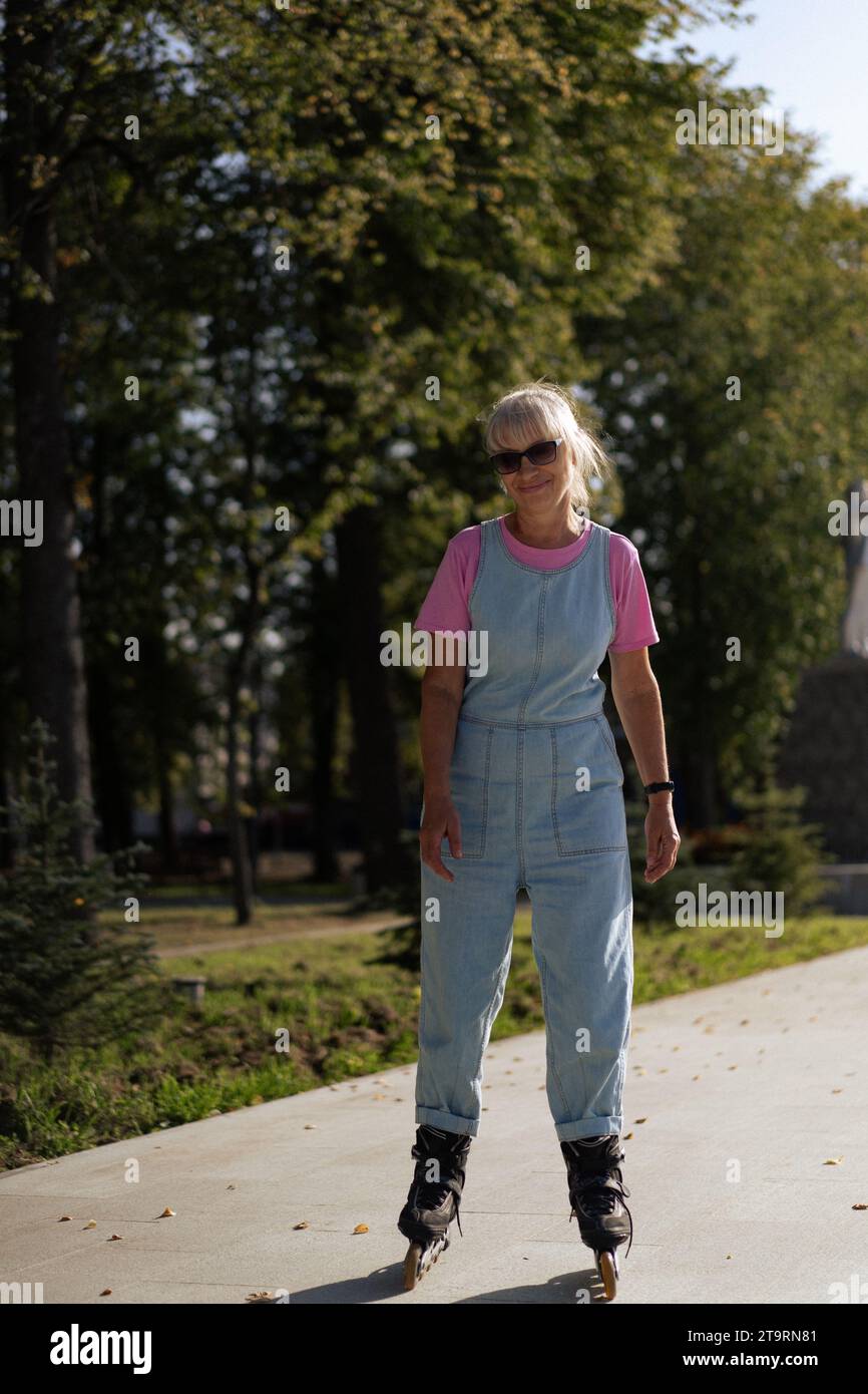 Middle-aged woman roller-skates in the city. Middle age entertainment. Stock Photo