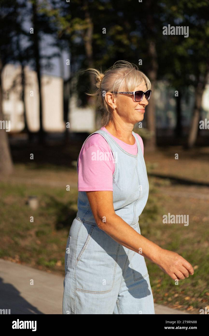 Middle-aged woman roller-skates in the city. Middle age entertainment. Stock Photo