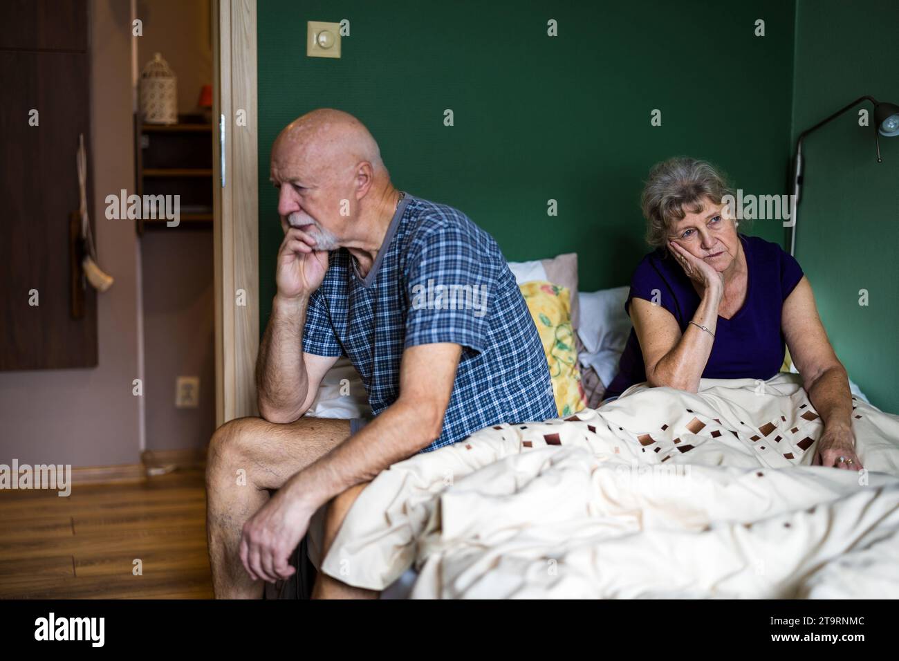 Senior couple is sitting on the bed having a relationship problems Stock Photo