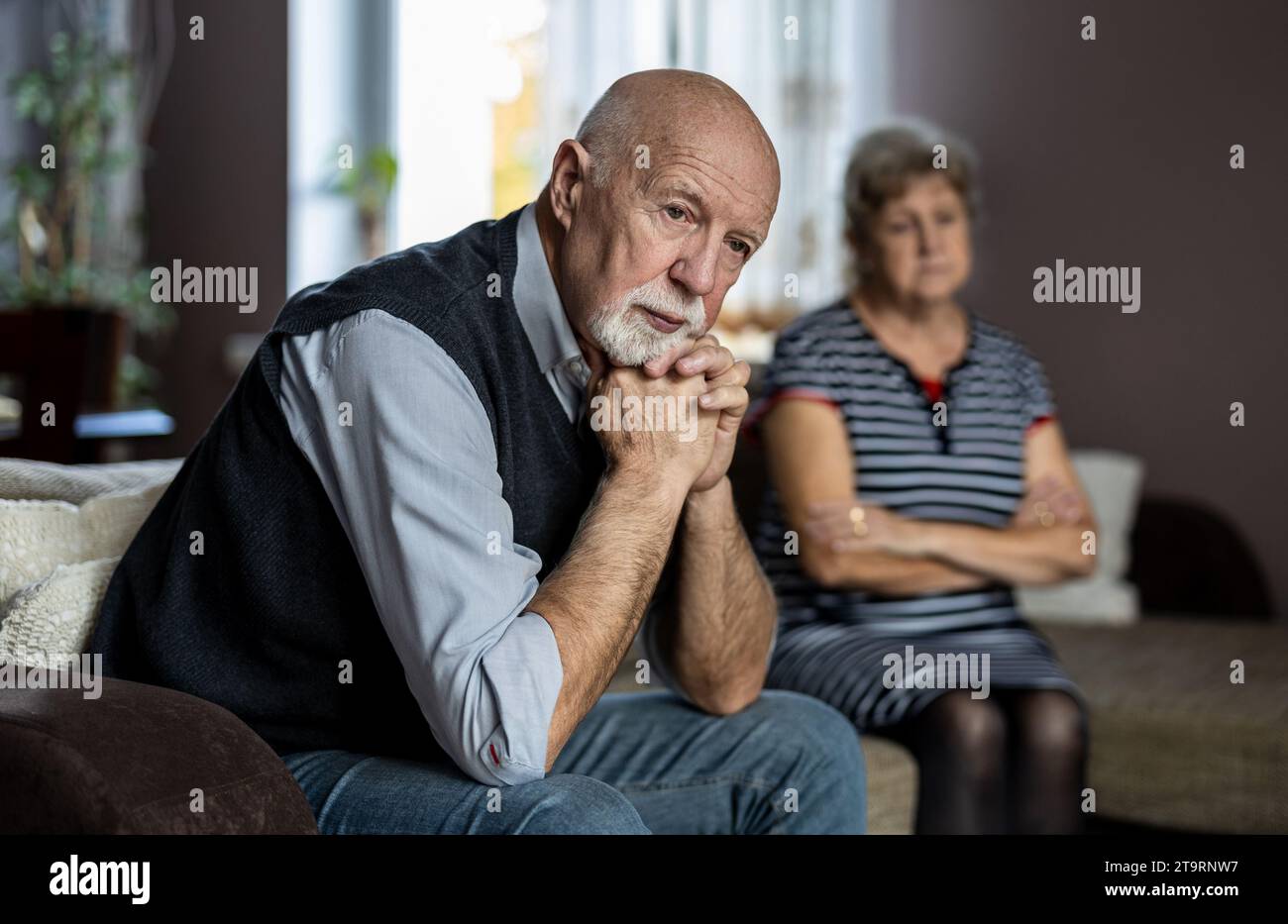 Senior couple sitting on sofa at home having a relationship problems Stock Photo