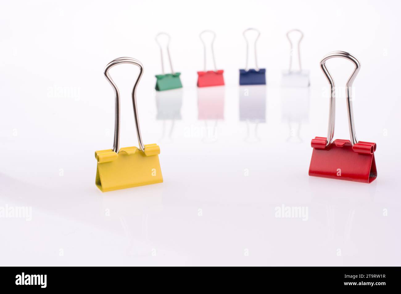 Colored paper clips on a white background Stock Photo