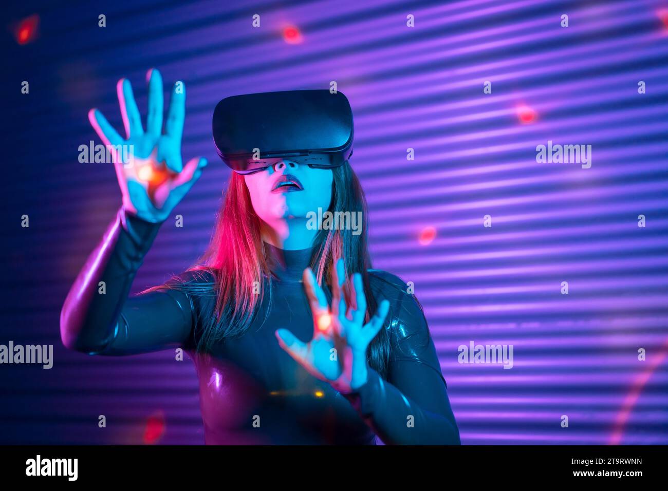 Woman during an interactive game with VR goggles in an urban night ...