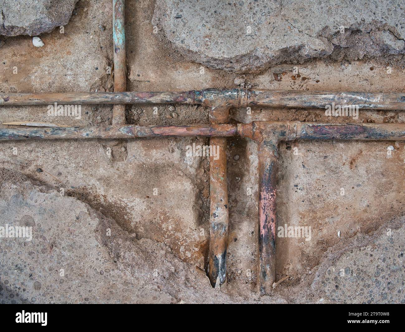 Exposed, leaking copper central heating pipes, badly corroded after