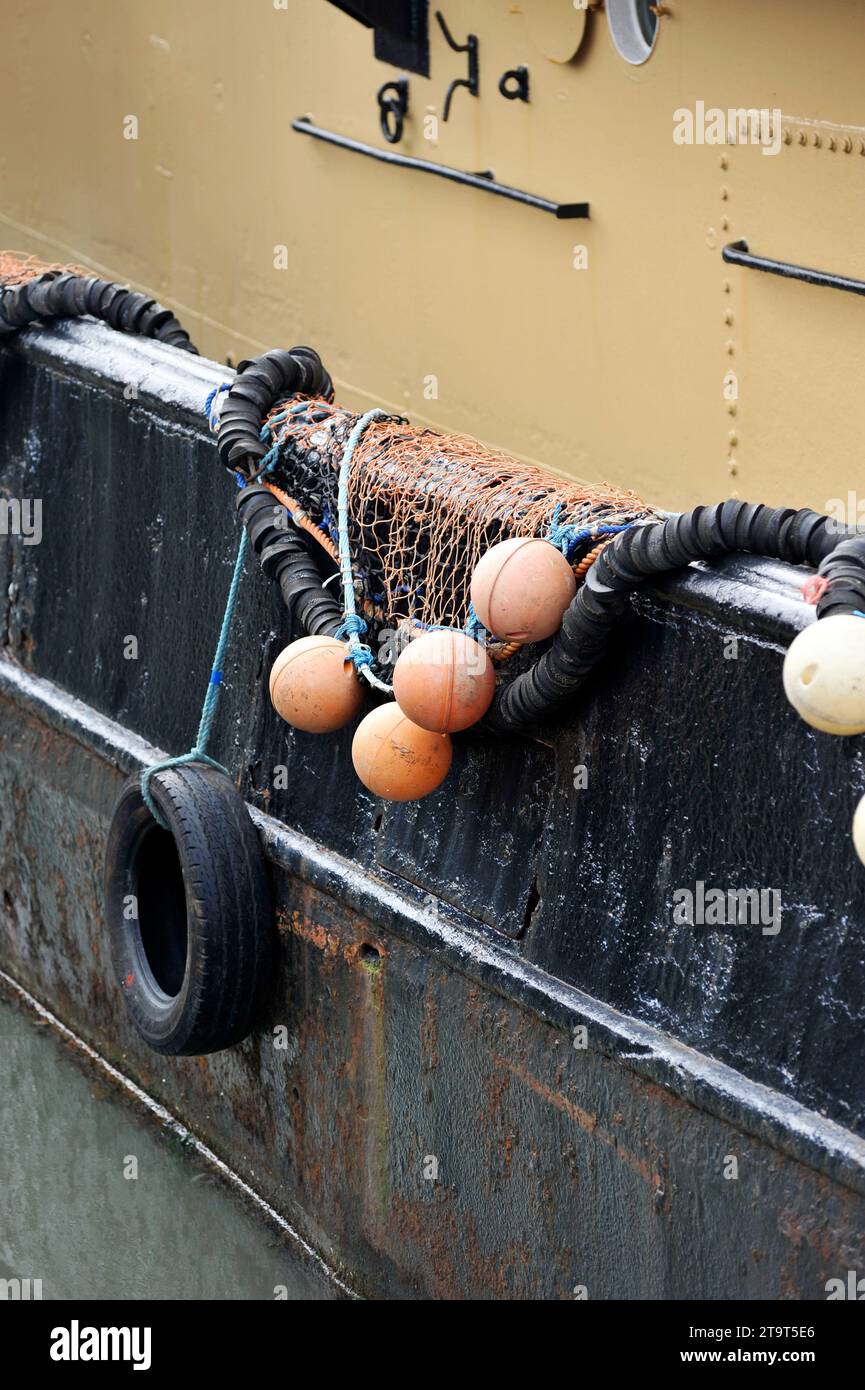 fishing nets and net floats on side of rusting fishing boat lowestoft suffolk england Stock Photo