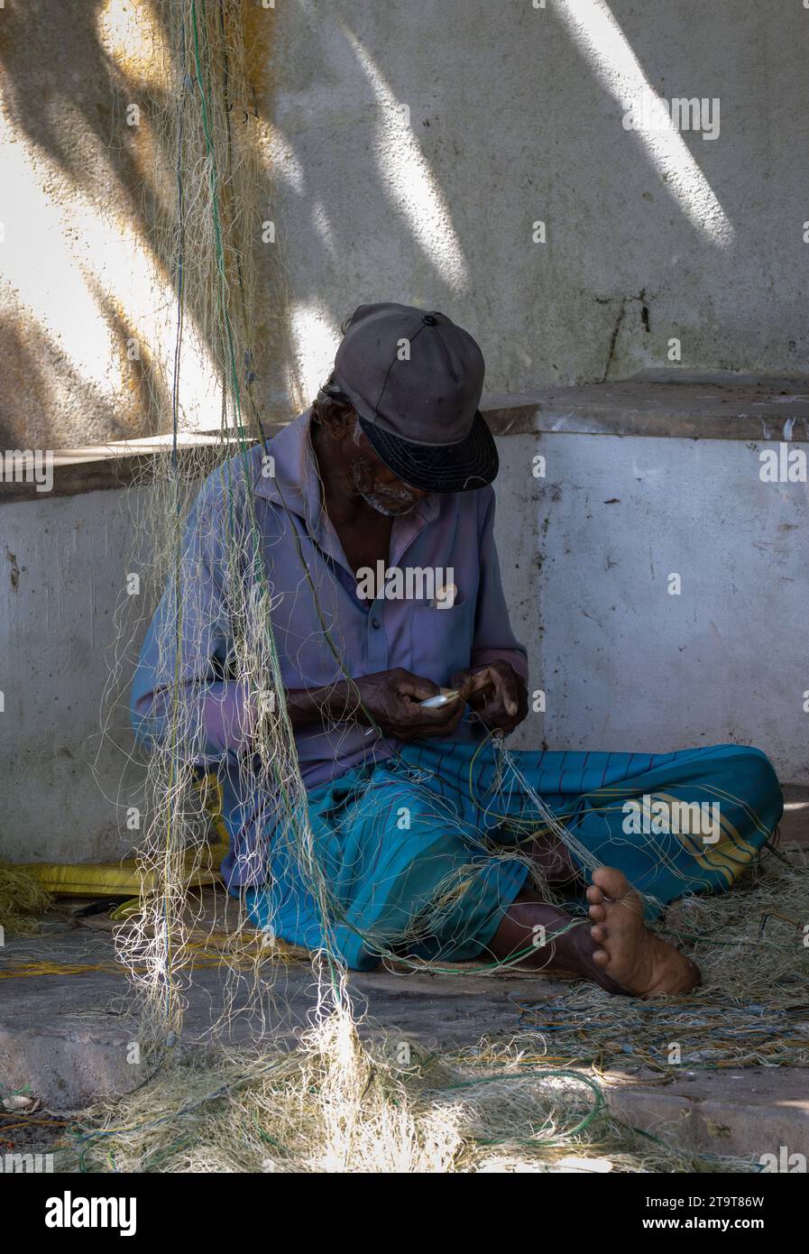 Fisherman repairing his fishing net in Sri Lanka Stock Photo