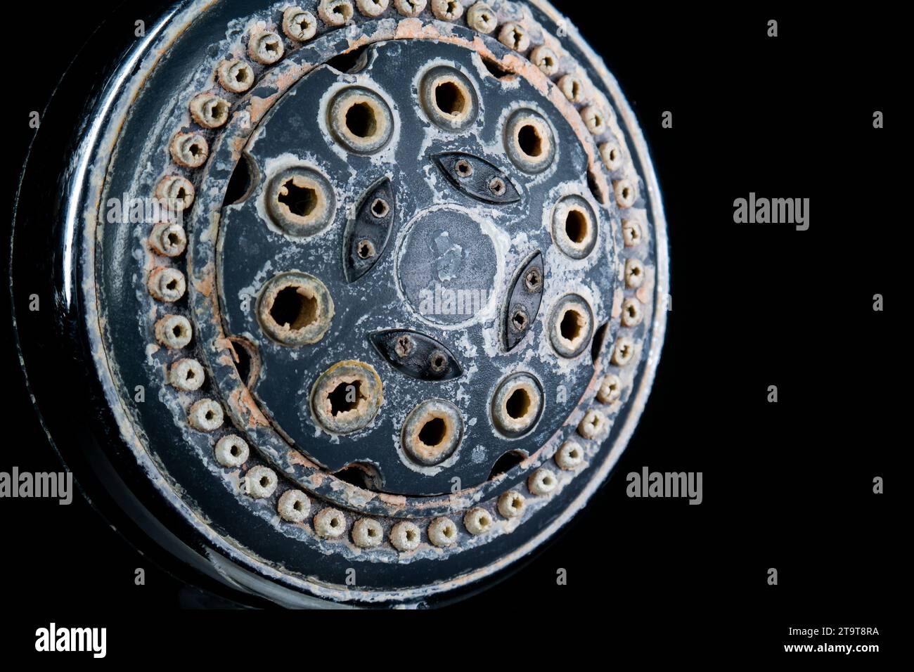 Hard water calcium or lime scale deposits on old, worn out shower head