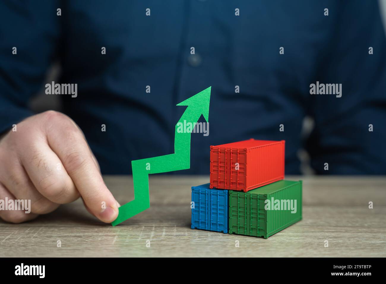 Shipping containers and a green arrow up. Increased transportation volumes and income growth. Increasing imports and exports, economic development. Hi Stock Photo