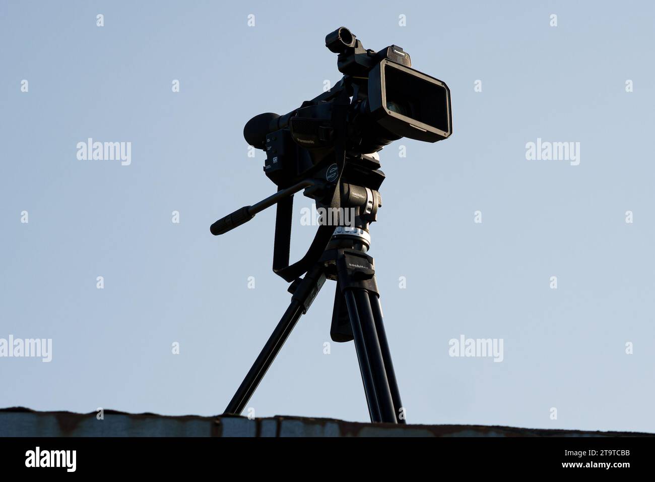 Professional Panasonic camera on a tripod, filming an airshow Stock Photo