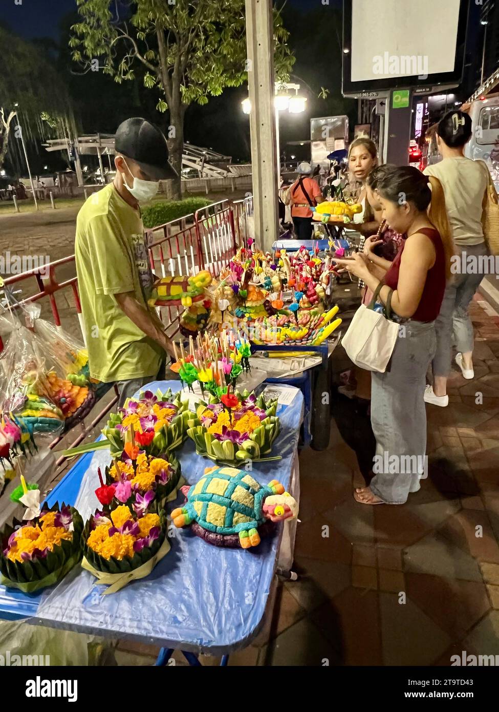 Bangkok, Thailand. 27th Nov, 2023. Thais buy the so-called Krathong, small rafts made from banana trees or expanded polystyrene with flowers, incense sticks and candles, at stalls. Thailand always celebrates the Loi Krathong festival of lights on the day of the full moon in the twelfth month of the traditional calendar. Small rafts are lowered into the water in rivers or lakes to pay homage to the Hindu water goddess Mae Phra Khongkha. Credit: Carola Frentzen/dpa/Alamy Live News Stock Photo