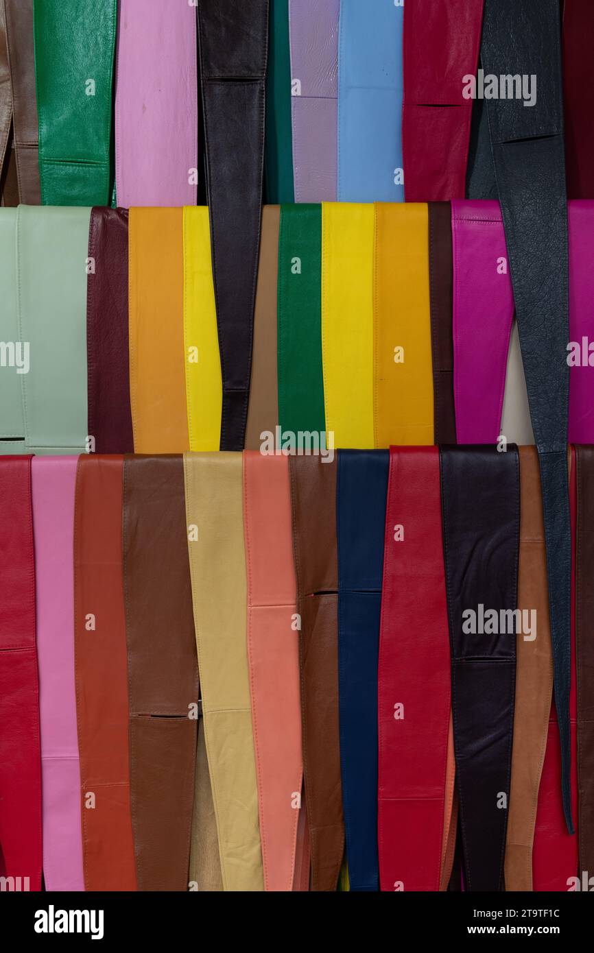 A variety of colorful leather belts and sashes on a display rack in an outdoor market in Florence, Italy. Stock Photo