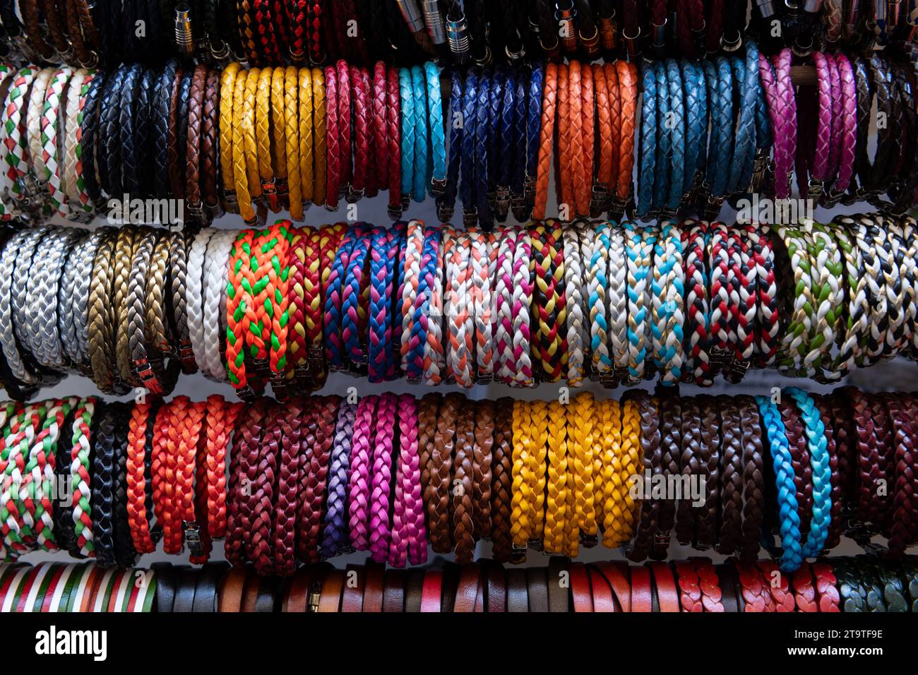 A variety of colorful, braided Italian leather bracelets displayed at an outdoor market in Florence, Italy. Stock Photo