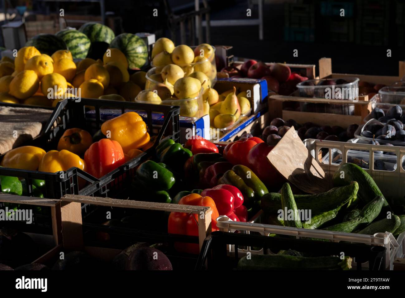 Variety of fruits and vegetables, including peppers, cucumbers, pears, lemons, watermelons and plums at an outdoor farmers' market in Florence, Italy. Stock Photo