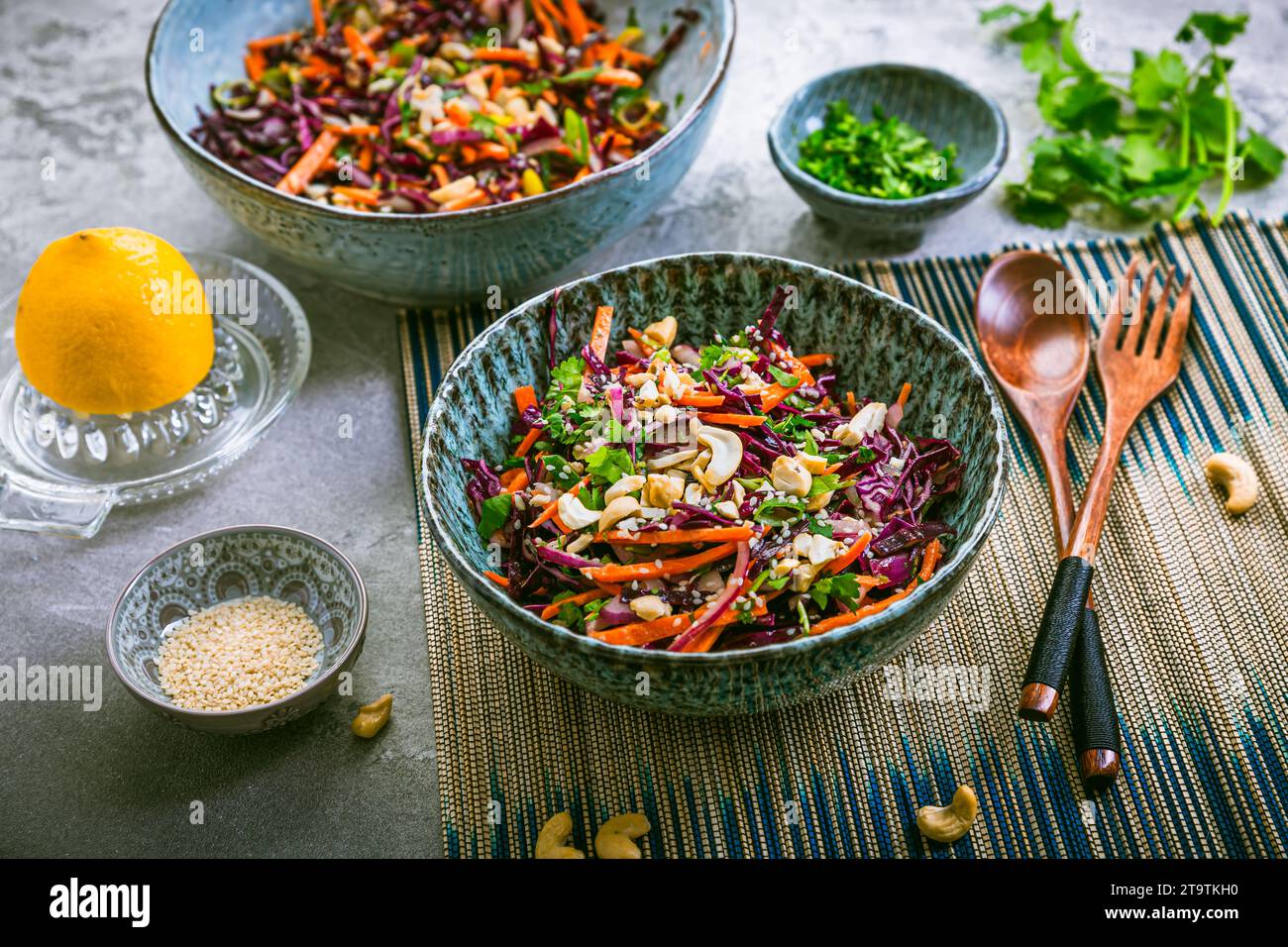 Red cabbage salad in Asian style with carrots, cilantro, cashew nuts and onions Stock Photo