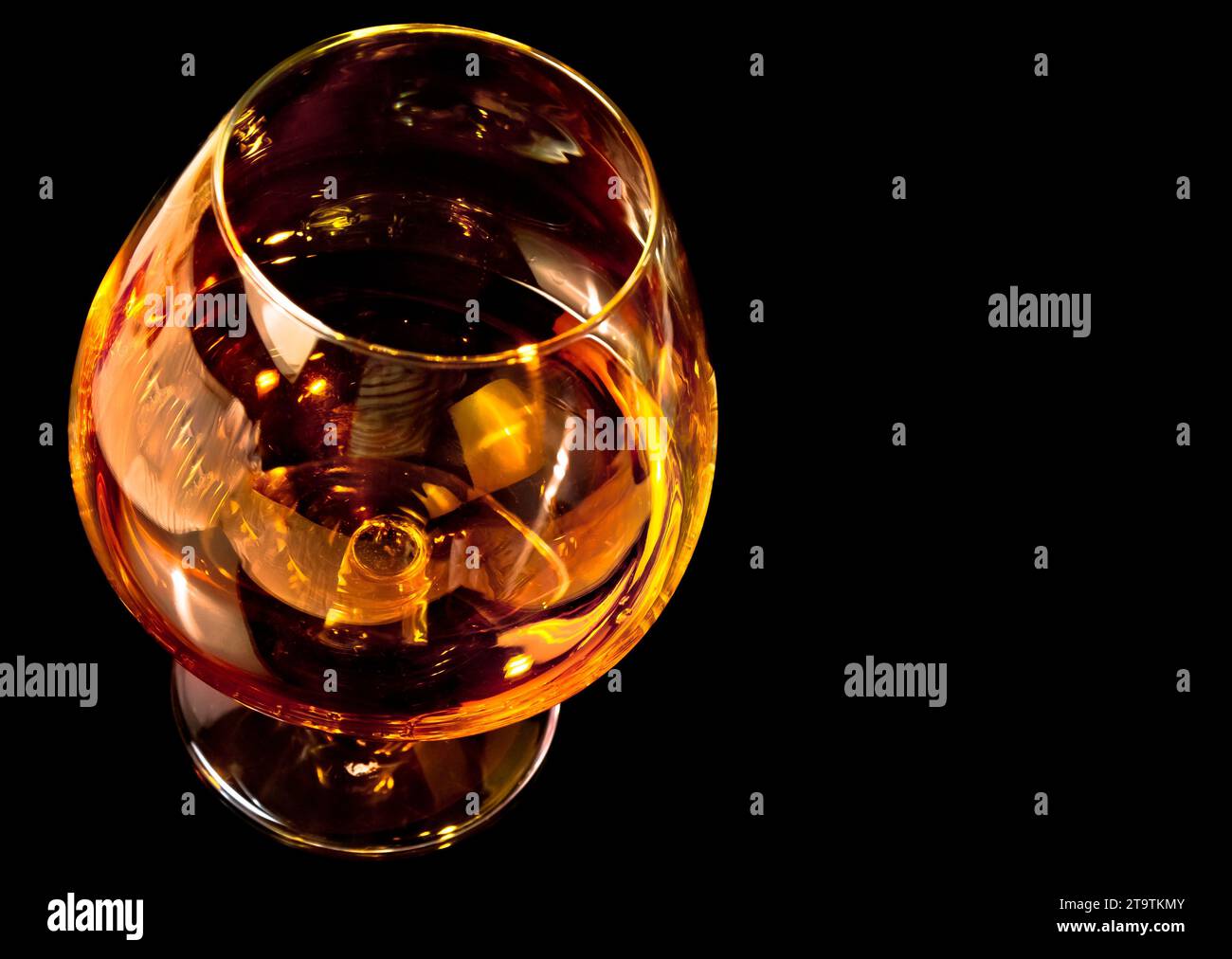 snifter of brandy in elegant typical cognac glass on black background ...