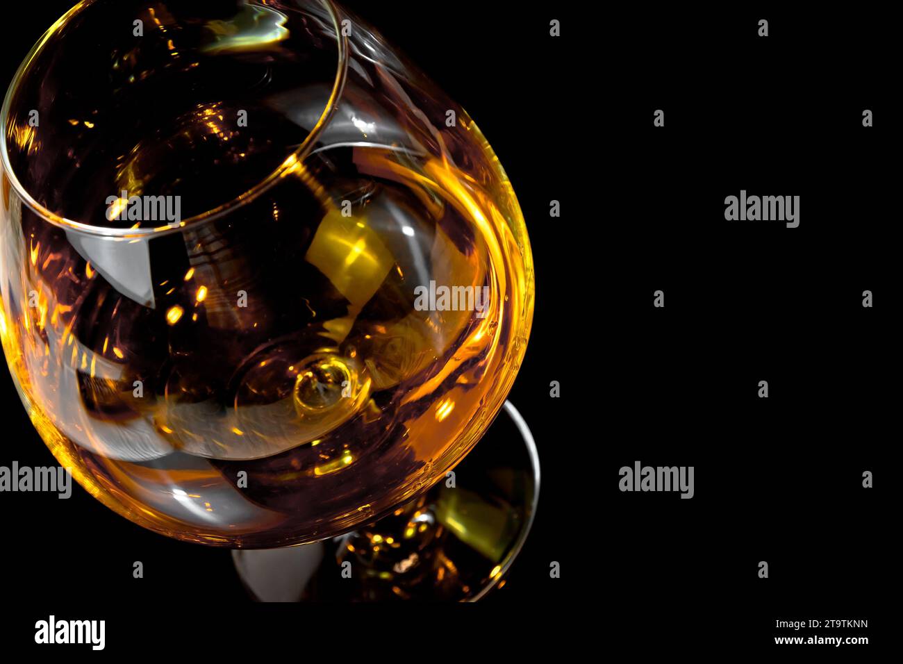 snifter of brandy in elegant typical cognac glass on black background