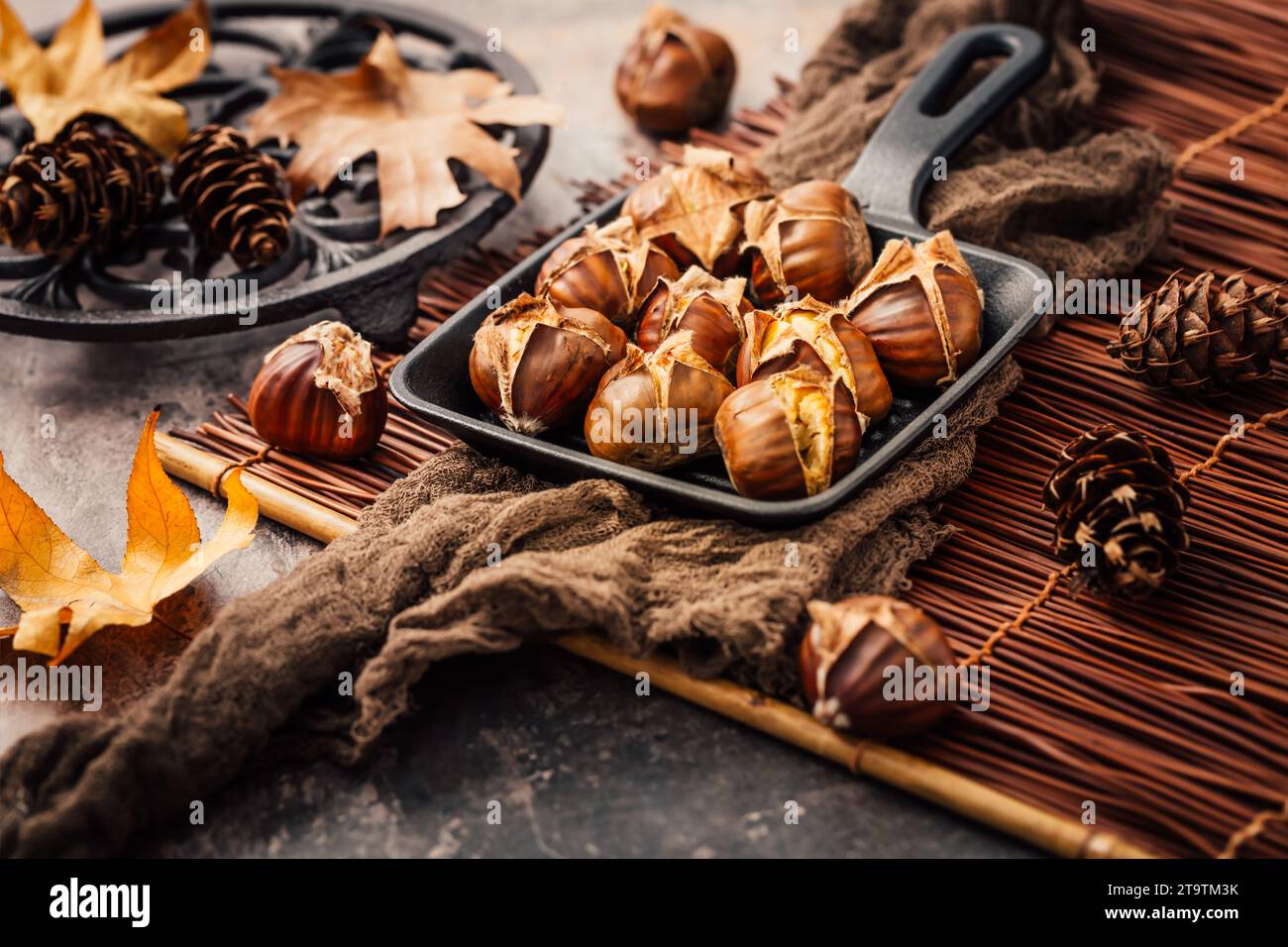 Roasted chestnuts in iron pan  on old kitchen table Stock Photo