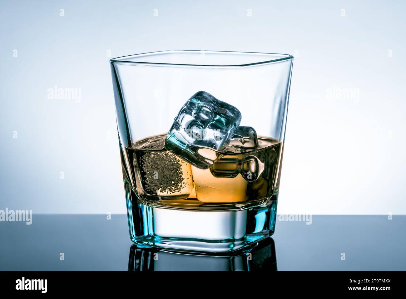 https://c8.alamy.com/comp/2T9TMXX/glass-of-whiskey-with-ice-cubes-on-bar-table-with-reflection-on-light-blue-tint-background-time-of-relax-with-whisky-2T9TMXX.jpg
