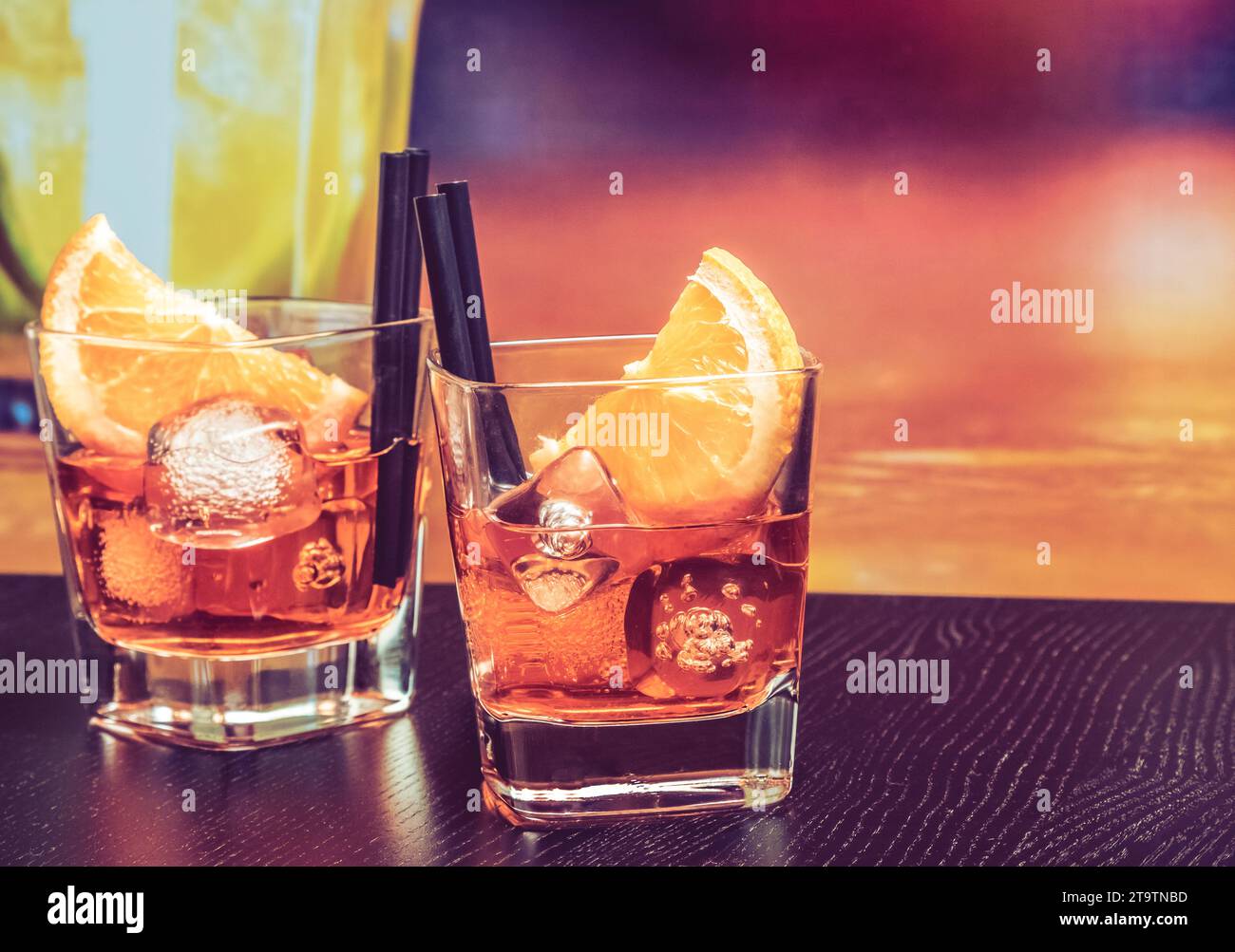 glasses of spritz aperitif aperol cocktail with orange slices and ice cubes on bar table, vintage atmosphere background, lounge bar concept Stock Photo