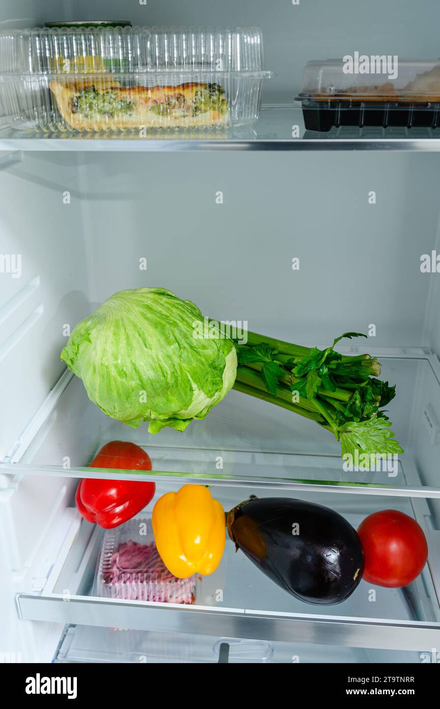 Fresh Vegetables lying on the shelf in the fridge. Fresh vegetable storage concept. Stock Photo
