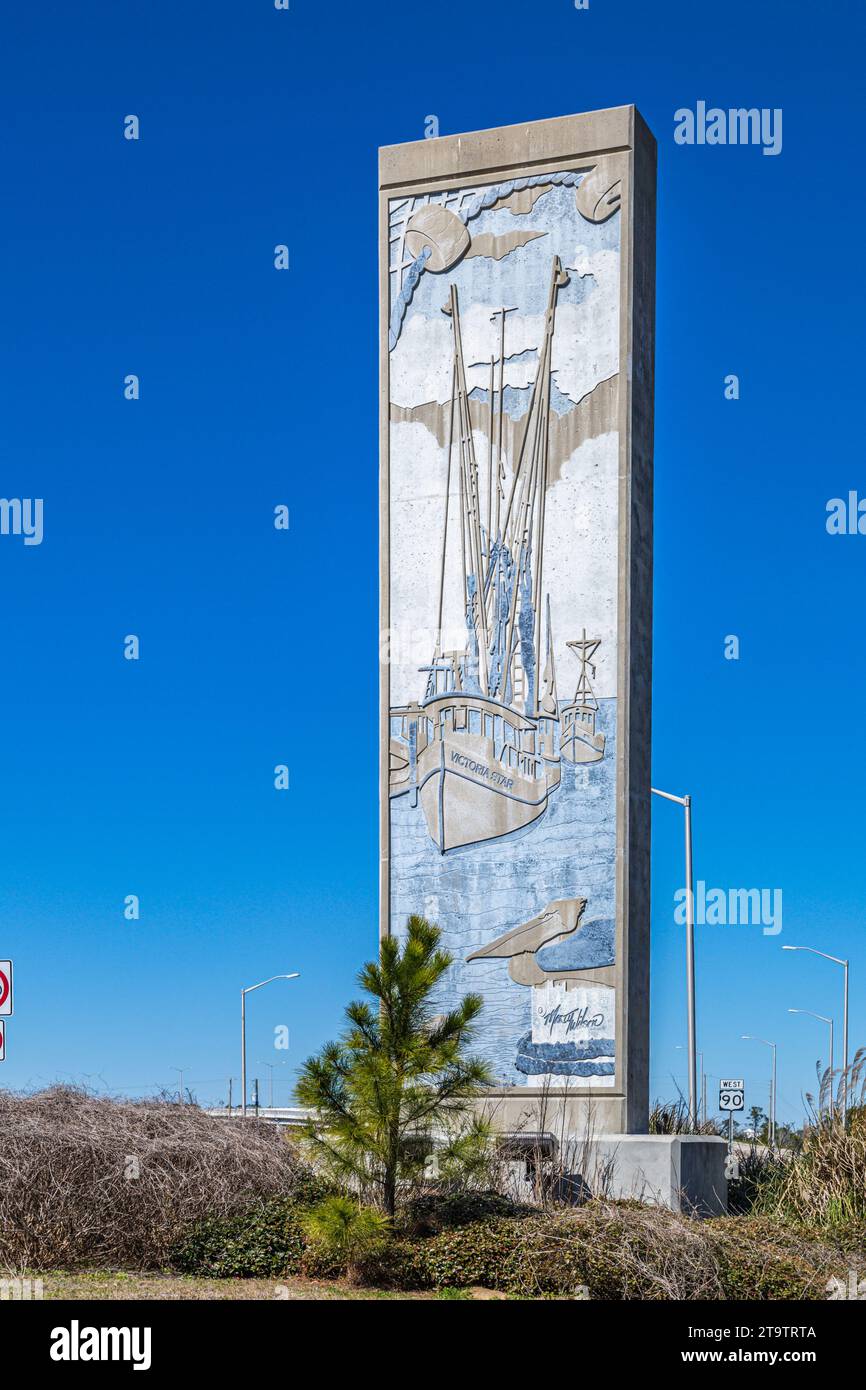 A bas-relief sign showing shrimp boats, created by Mississippi artist Marty Wilson, welcomes tourists to Bay Saint Louis, Mississippi Stock Photo