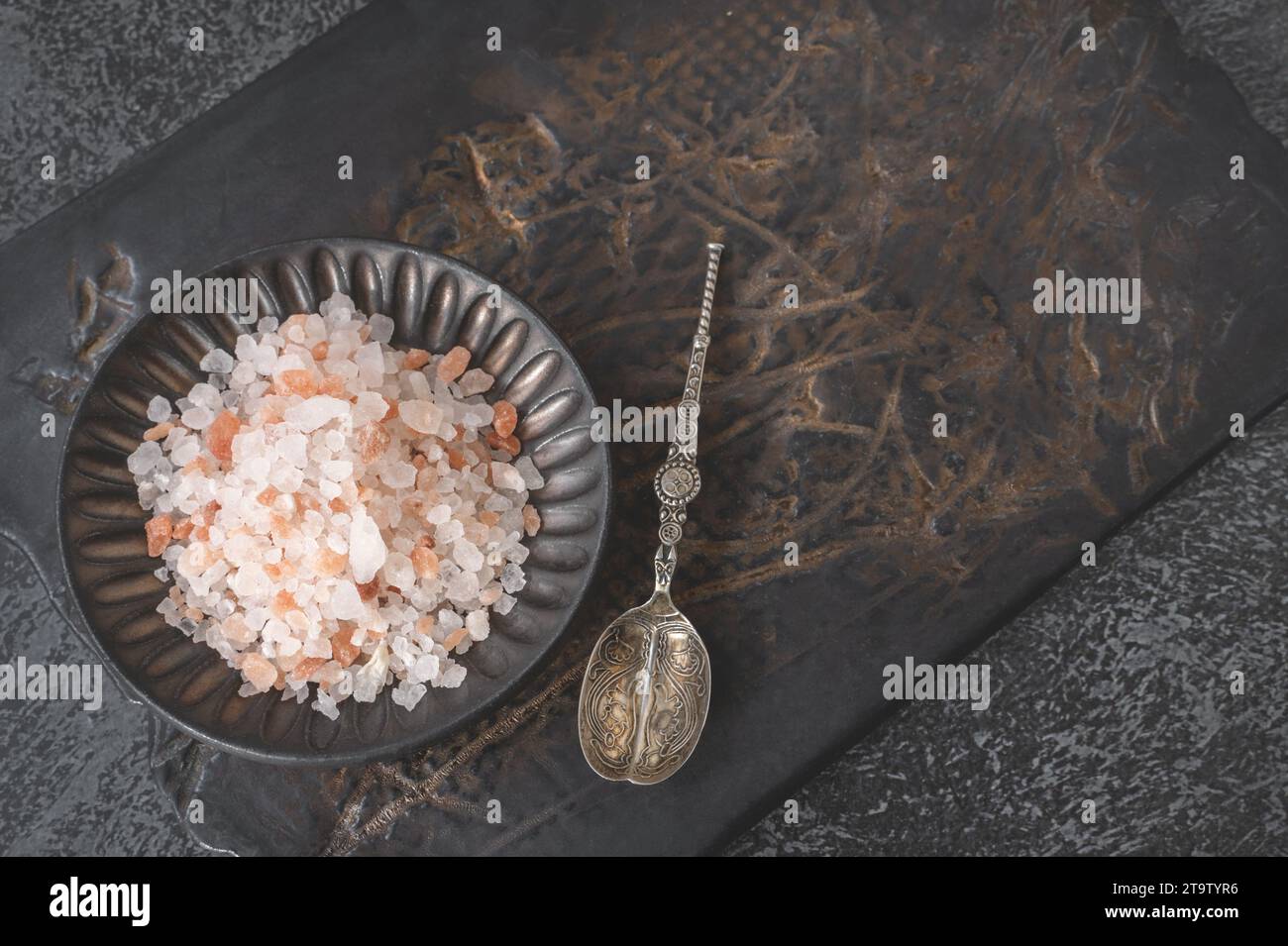 Himalayan pink salt in a handmade kraft plate on a clay cutting board. Top view. Copy space Stock Photo