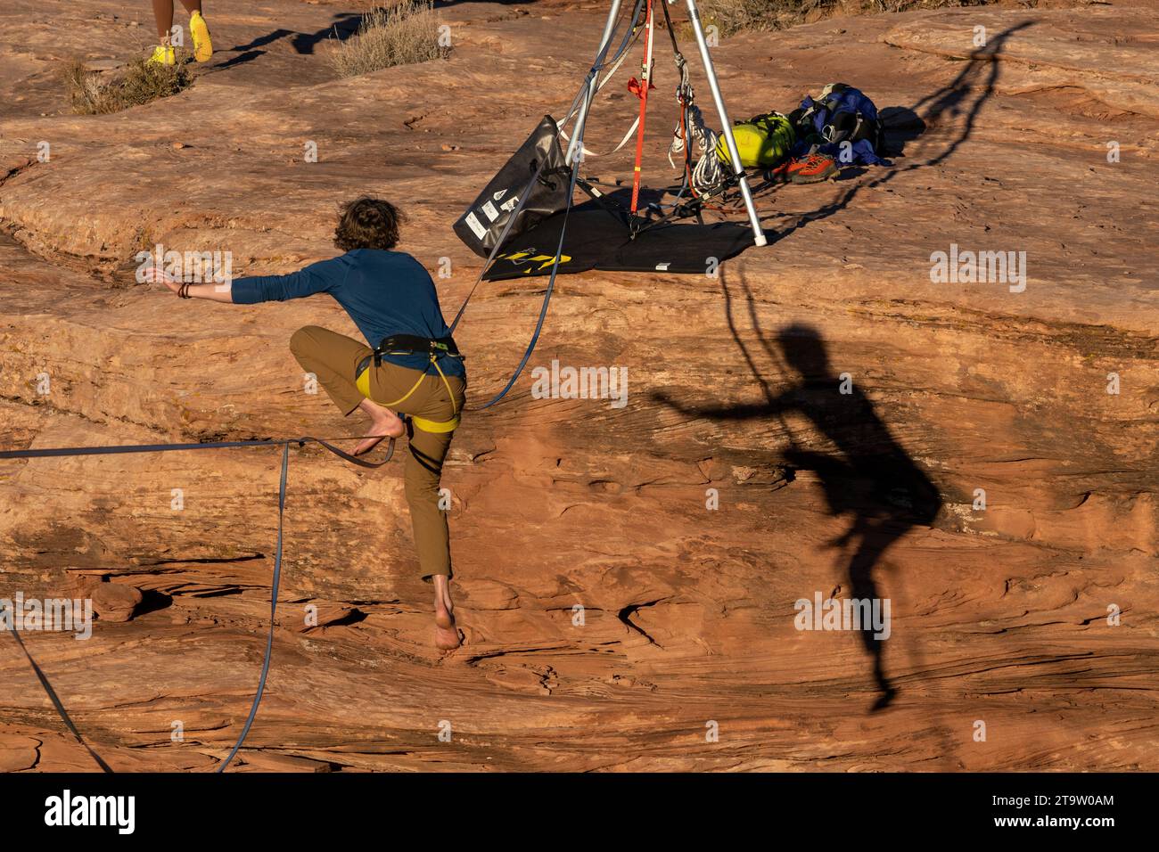 A man remounts the highline after a fall over Mineral Canyon at the GGBY World Highline Festival near Moab, Utah. Stock Photo