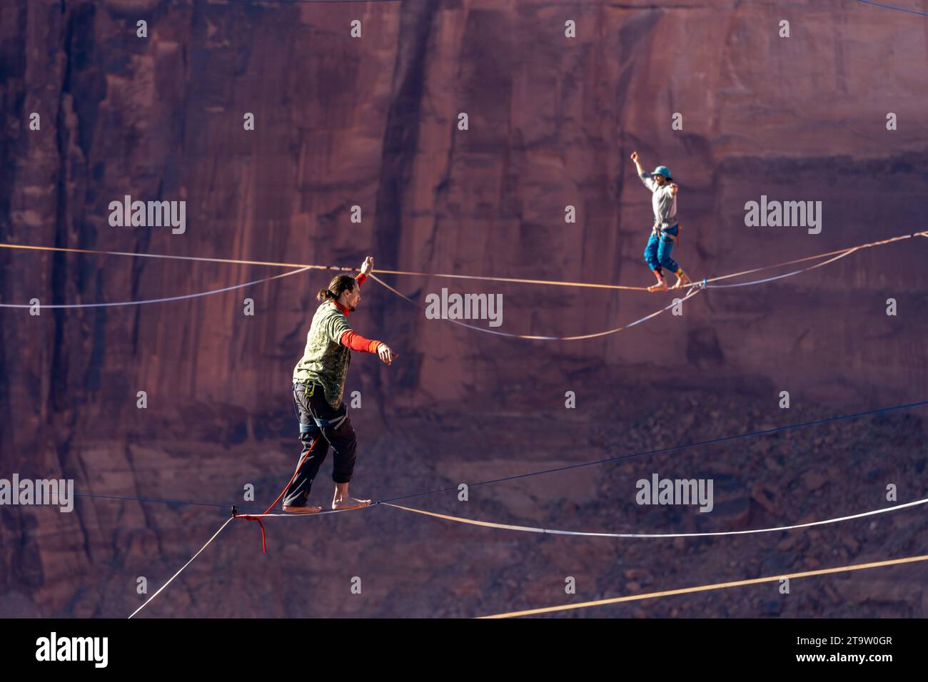 Two men on highlines at the GGBY World Highline Festival 500 feet above Mineral Canyon near Moab, Utah. Stock Photo