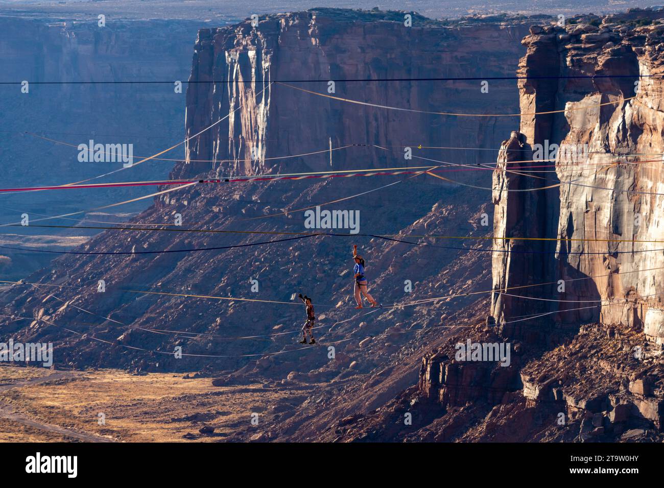 Two people on highlines at the GGBY World Highline Festival 500 feet above Mineral Canyon near Moab, Utah. Stock Photo