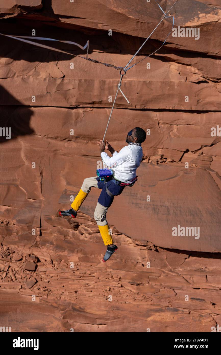 A male highliner wearing a blindfold loses his balance and whips, or falls off the highline at a highline festival in Utah.  His protective harness & Stock Photo