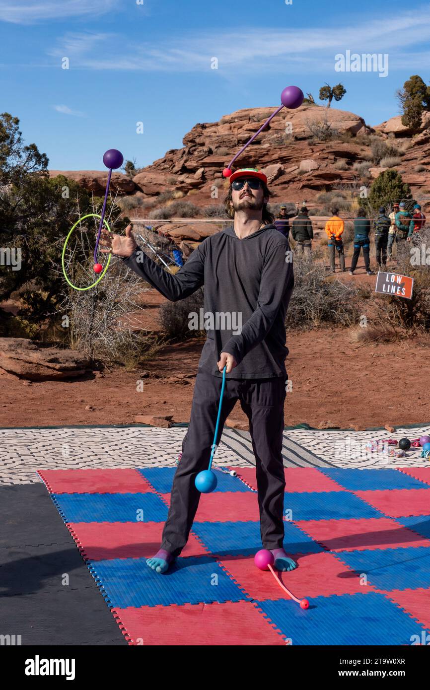 A participant in the GGBY Highlining Festival practices his juggling while not walking the highlines.  Moab, Utah. Stock Photo